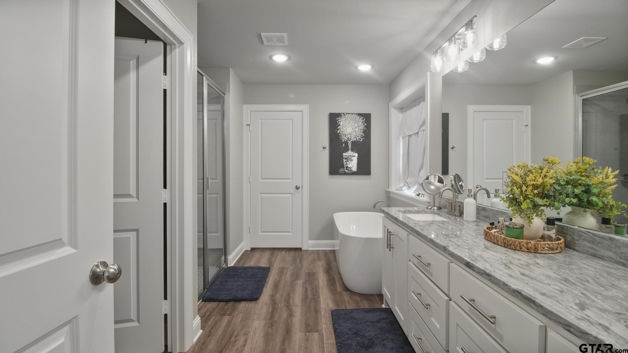 14144 Foxtail Drive Flint, TX 75762 - Photo 15 of 39 a spacious bathroom with a granite countertop sink a toilet a mirror and shower