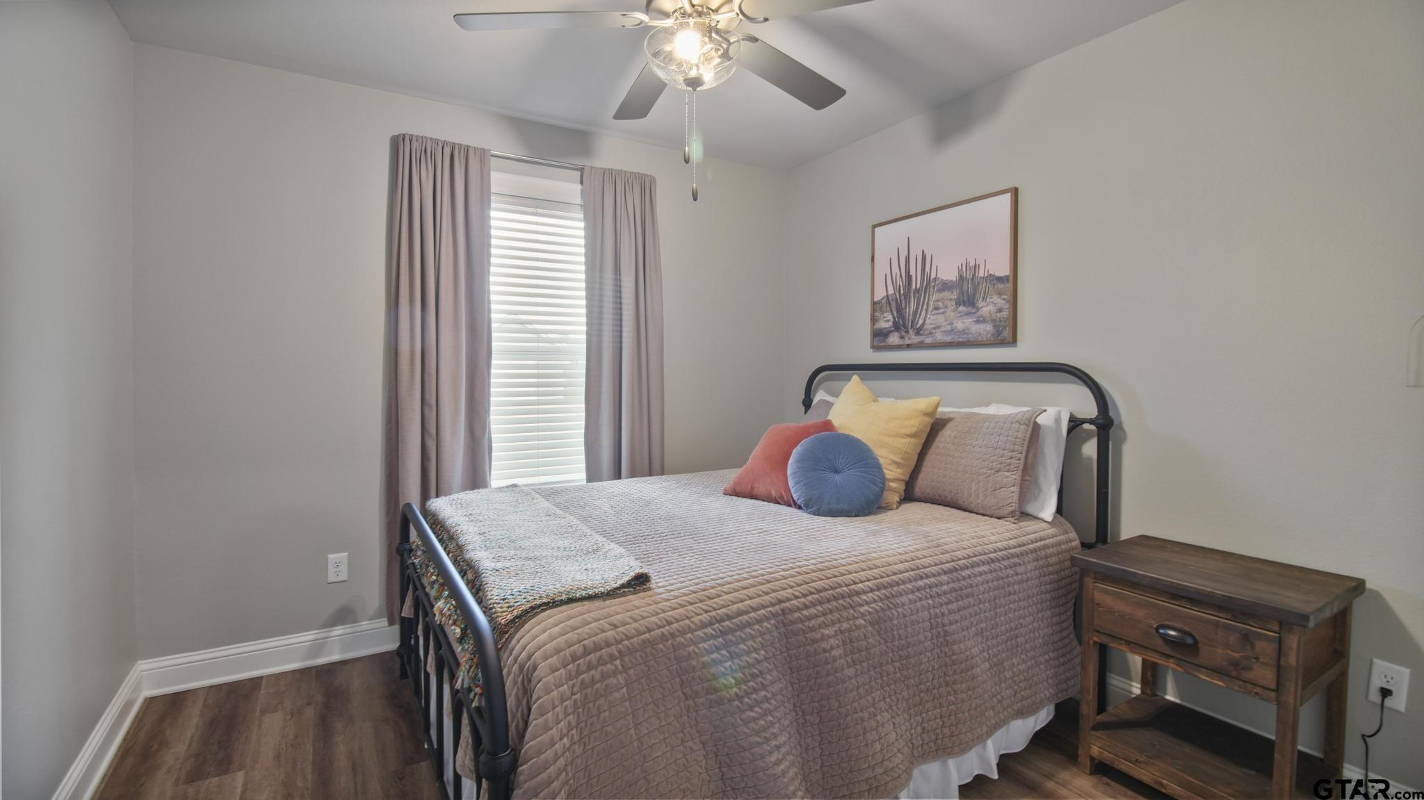 14144 Foxtail Drive Flint, TX 75762 - Photo 24 of 39 a bedroom with a bed and a chandelier