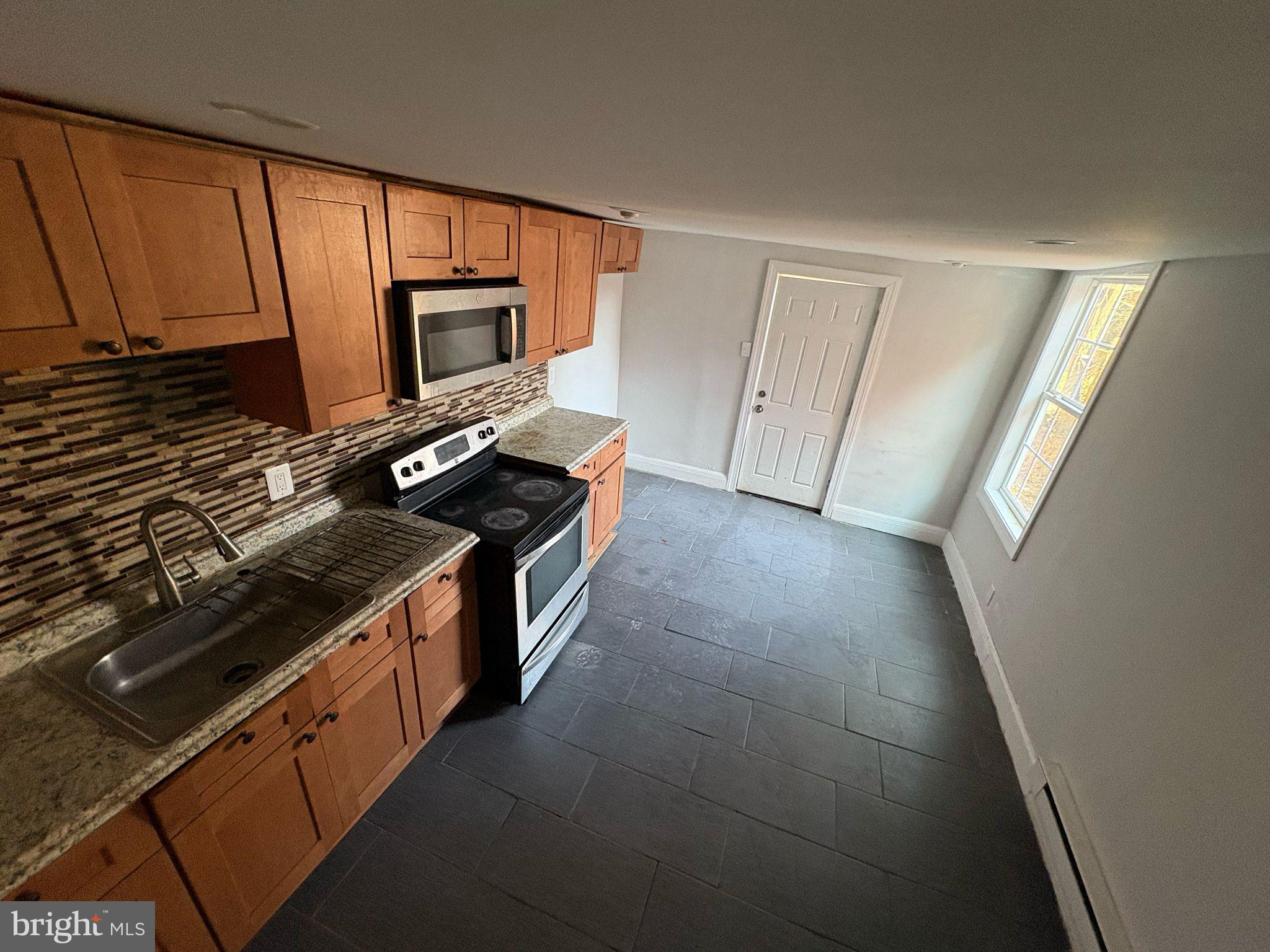 a kitchen with wooden cabinets and a stove top oven