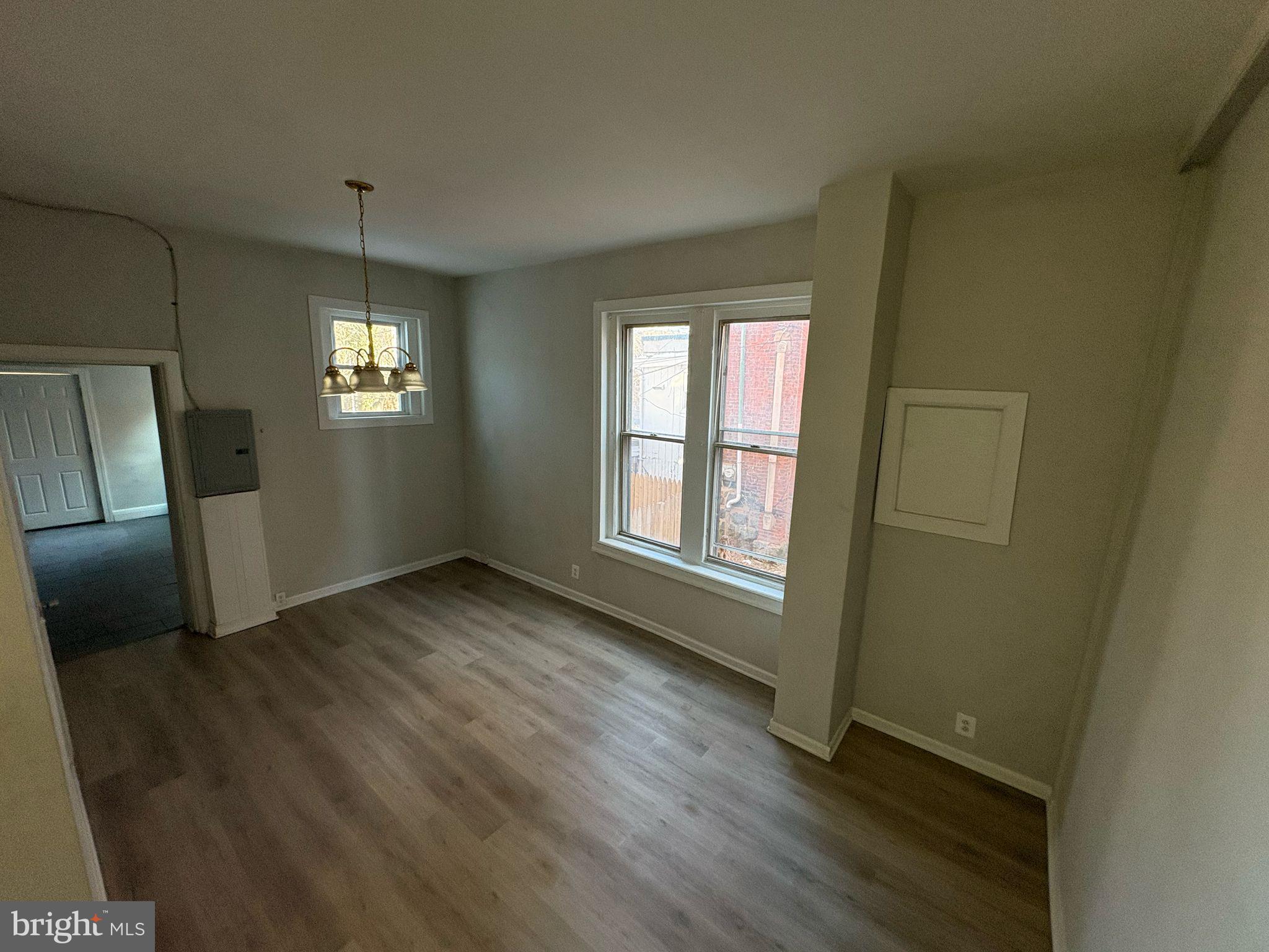 861 Wynnewood Road, Unit 1 Philadelphia, PA 19151 - Photo 4 of 5 an empty room with wooden floor and windows