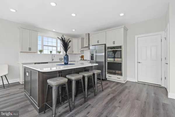 a kitchen with refrigerator cabinets and wooden floor