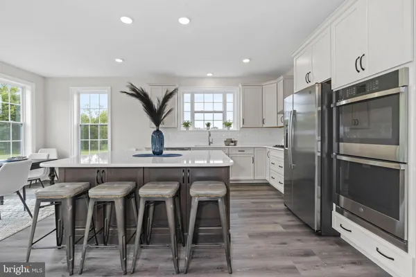 a kitchen with a table chairs refrigerator and window