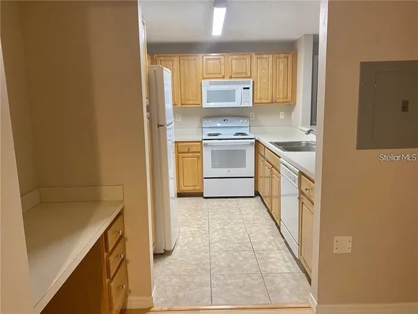a kitchen with granite countertop a sink stove and cabinets