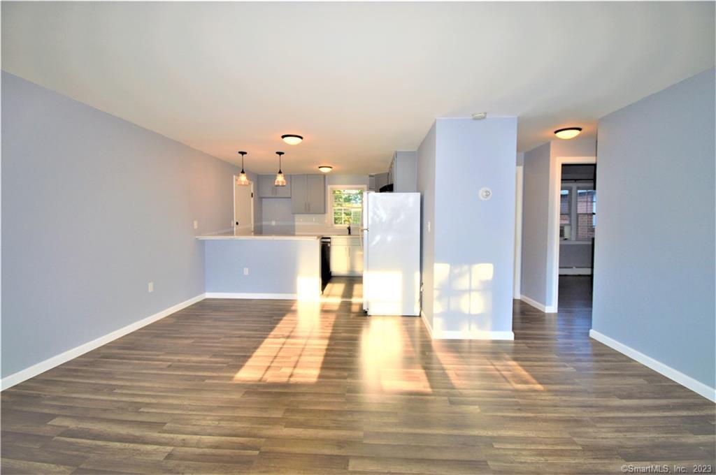 a view of a living room with kitchen island microwave and refrigerator
