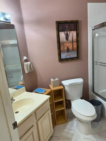 a bathroom with a toilet a sink and mirror