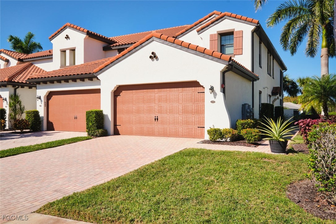 11856 Arboretum Run Drive, Unit 102 Fort Myers, FL 33913 - Photo 1 of 47 a front view of a house with a yard and garage