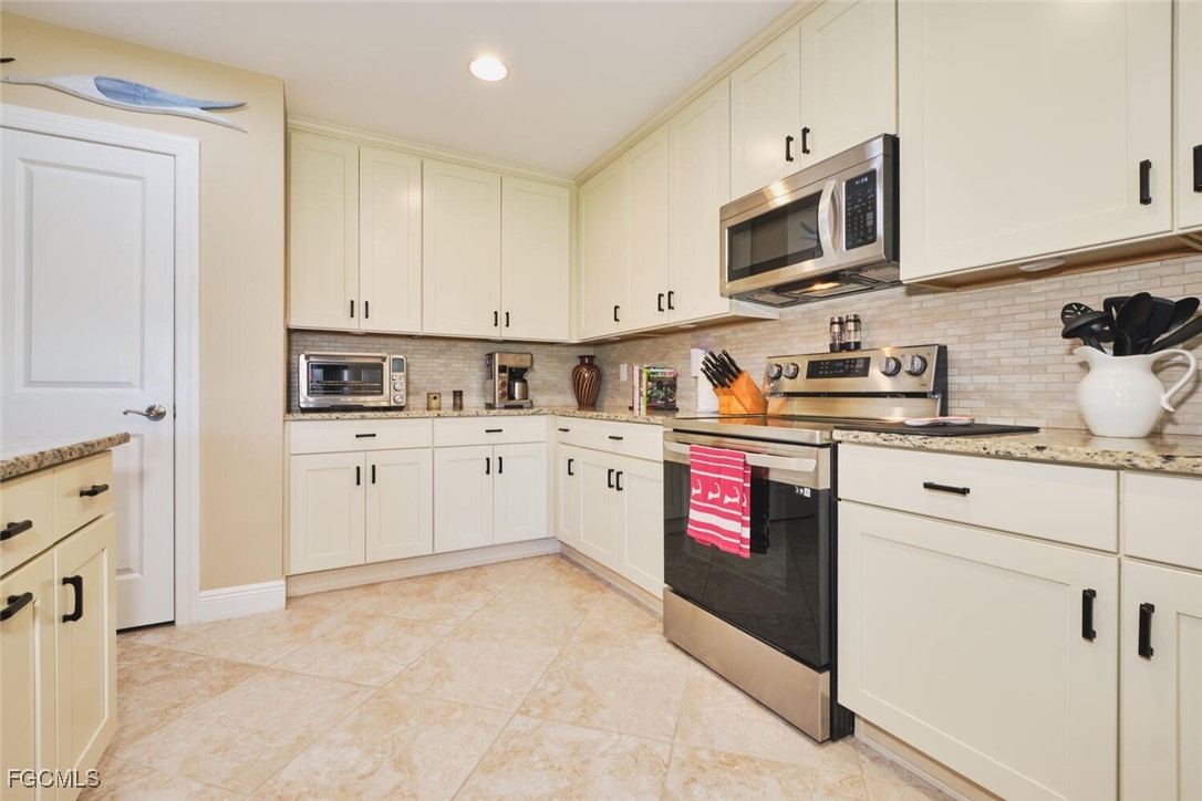 11856 Arboretum Run Drive, Unit 102 Fort Myers, FL 33913 - Photo 14 of 47 a kitchen with stainless steel appliances granite countertop a sink and cabinets