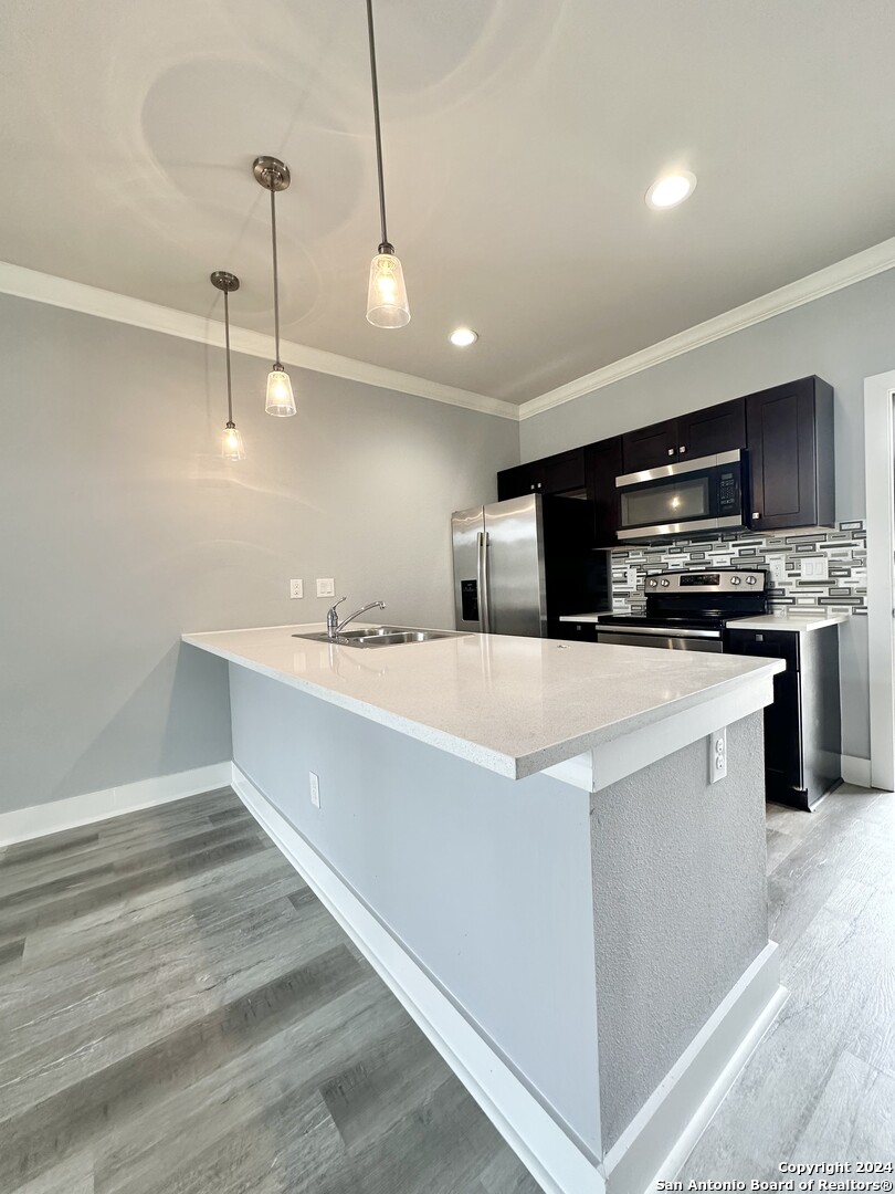 831 Terrell Road, Unit 103 San Antonio, TX 78209 - Photo 5 of 11 a kitchen with kitchen island a sink stainless steel appliances and cabinets