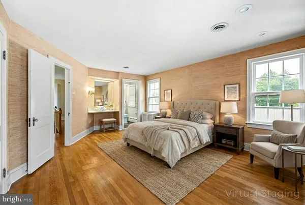 a spacious bedroom with a bed a couch and large window