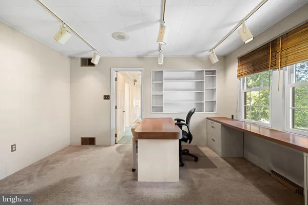 a room with a bed and windows