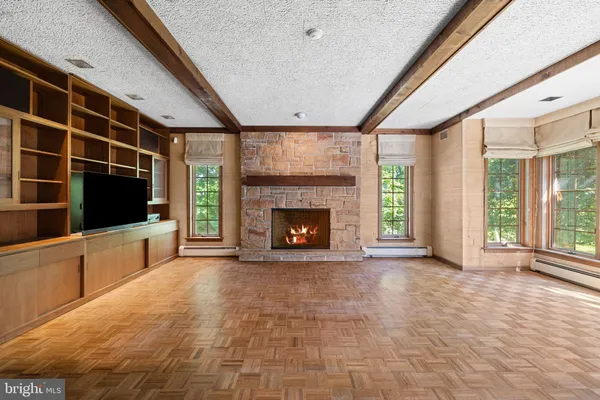 a view of an empty room with a fireplace and a window