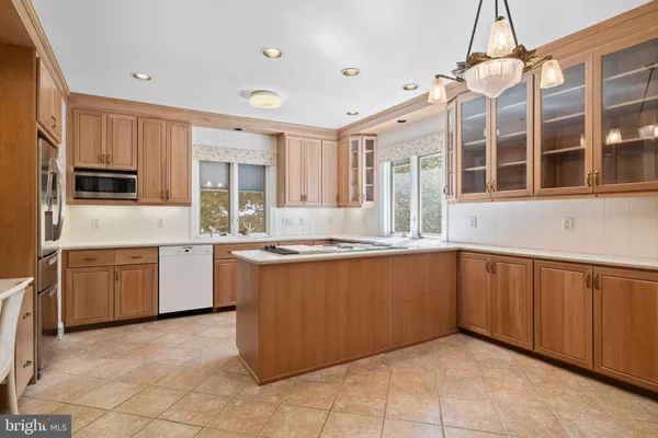 a kitchen with kitchen island granite countertop a sink window and cabinets