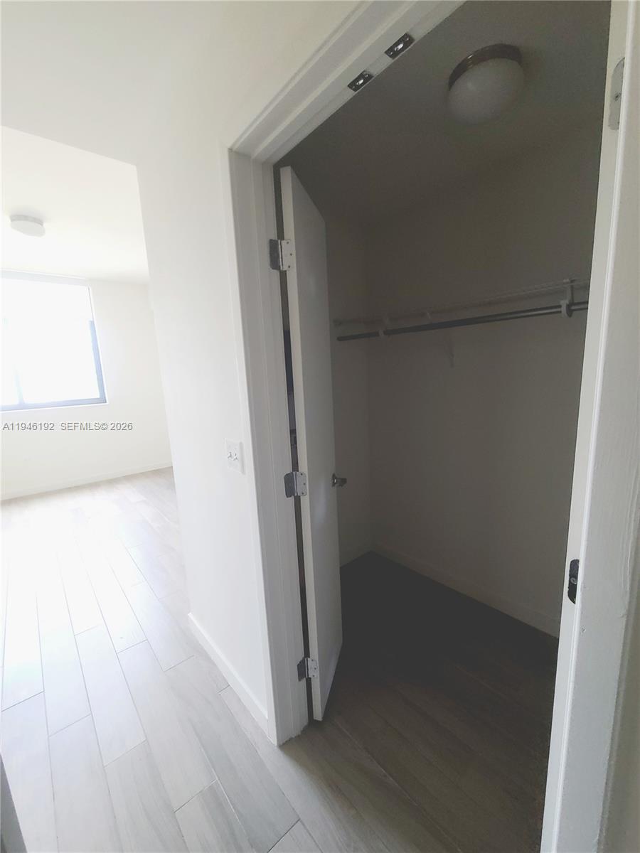999 Southwest 1st Avenue, Unit 1808 Miami, FL 33130 - Photo 14 of 16 view of a room with wooden floor