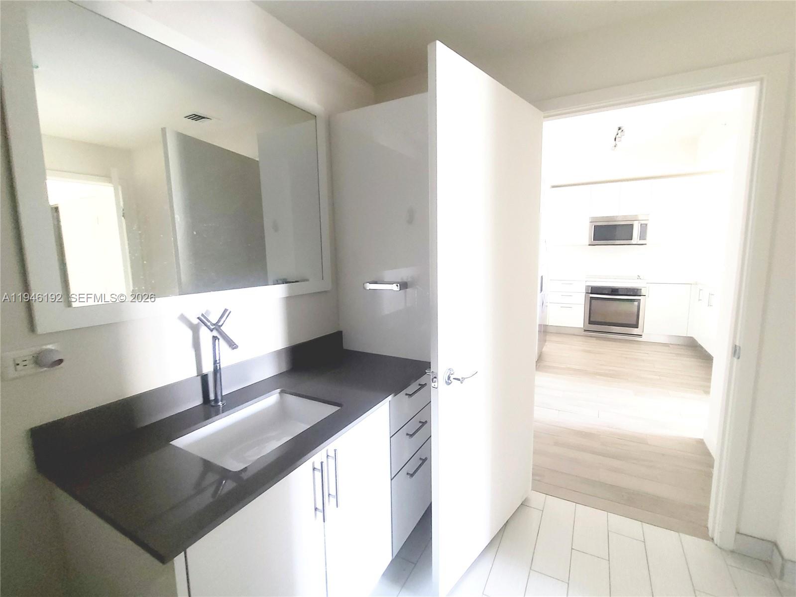 999 Southwest 1st Avenue, Unit 1808 Miami, FL 33130 - Photo 15 of 16 a bathroom with a sink and a mirror