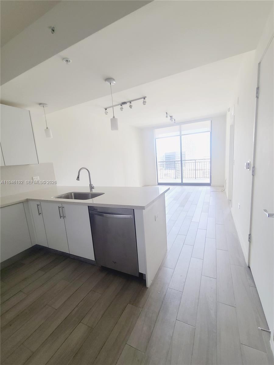 999 Southwest 1st Avenue, Unit 1808 Miami, FL 33130 - Photo 7 of 16 a kitchen with wooden floors and sink