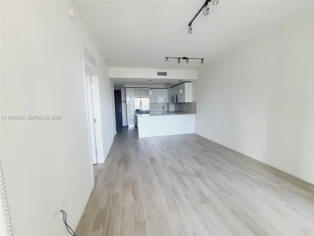 a view of a kitchen with a sink and wooden floor