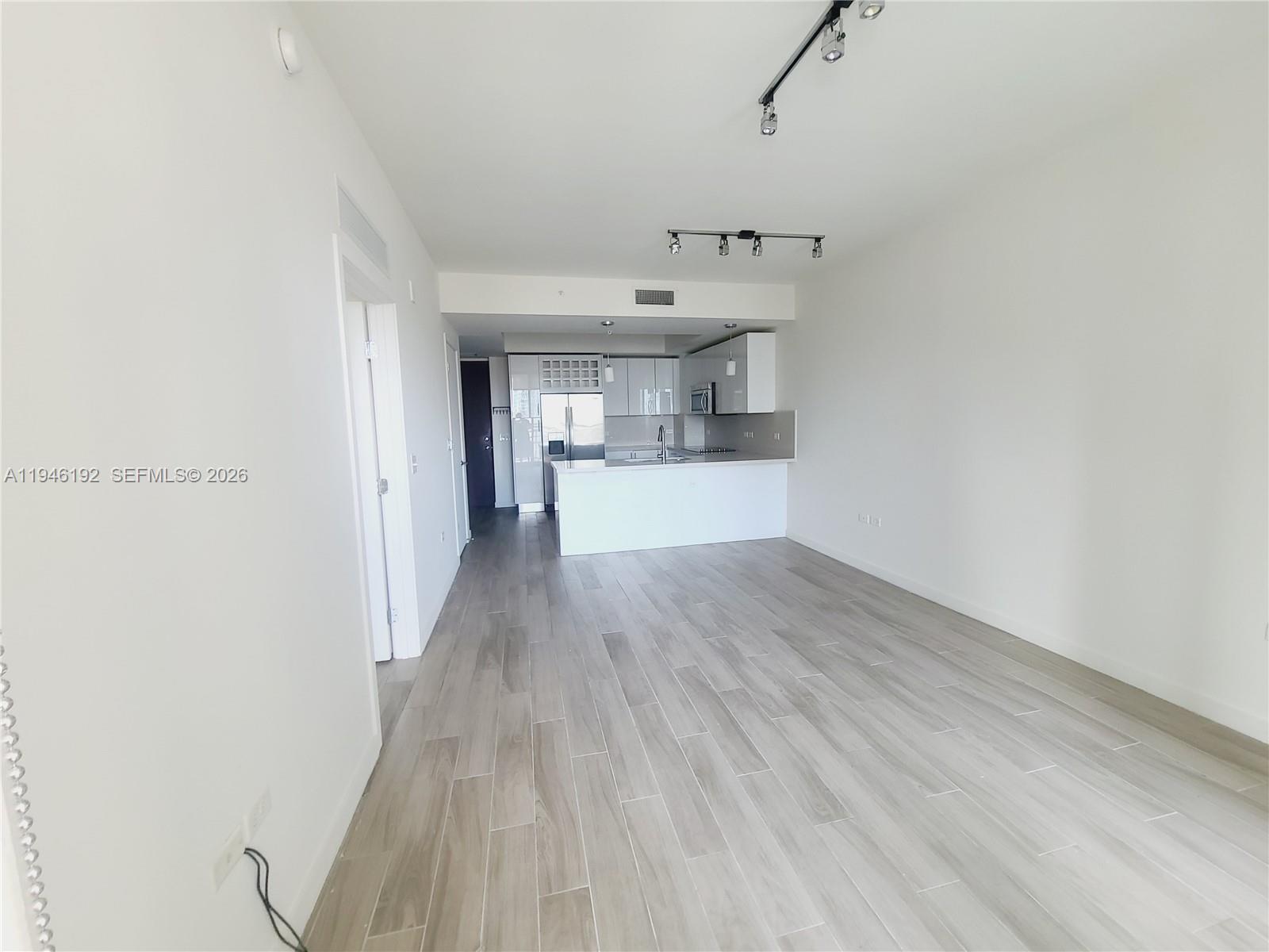 999 Southwest 1st Avenue, Unit 1808 Miami, FL 33130 - Photo 8 of 16 a view of a kitchen with a sink and wooden floor