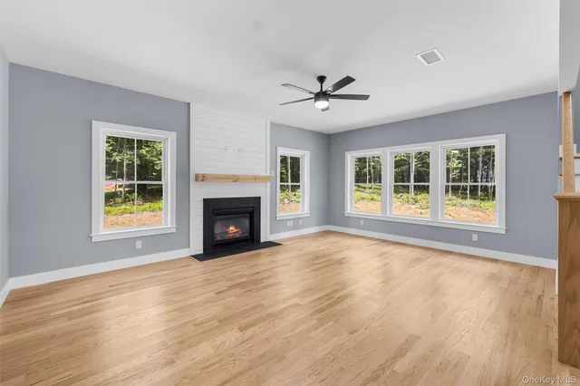 a view of a livingroom with wooden floor and a fireplace