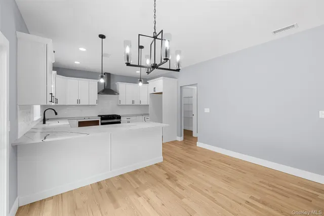 a view of a kitchen with stainless steel appliances wooden floor and a window