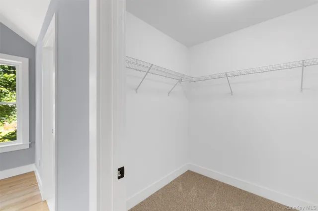 a view of empty room with wooden floor and ceiling fan