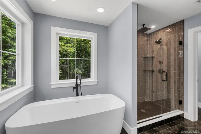 a spacious bathroom with a double vanity sink mirror and bathtub