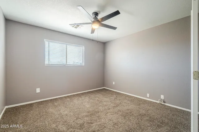 an empty room and chandelier fan