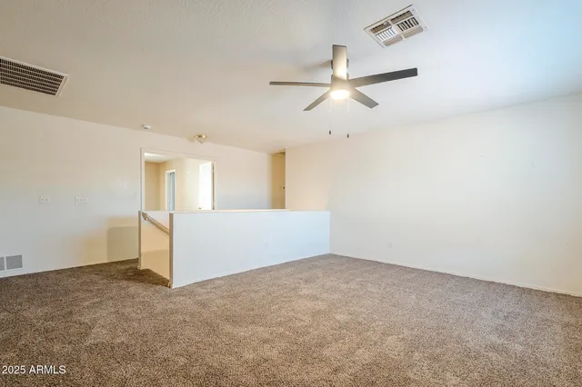 an empty room with a window and a fan
