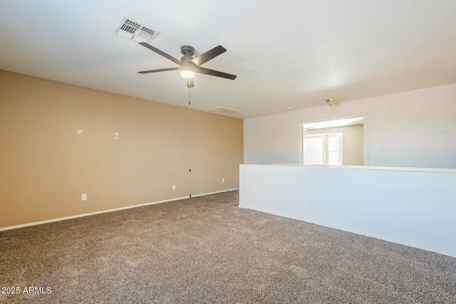 an empty room with closet and a chandelier fan