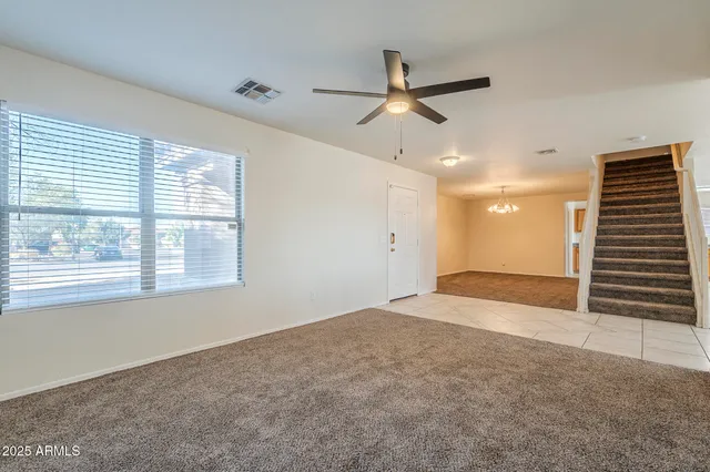 en empty room with windows and ceiling fan