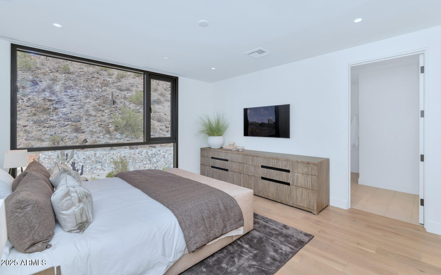 5000 East Camelback Road, Unit 407 Scottsdale, AZ 85253 - Photo 15 of 39 a bedroom with a bed and a flat screen tv