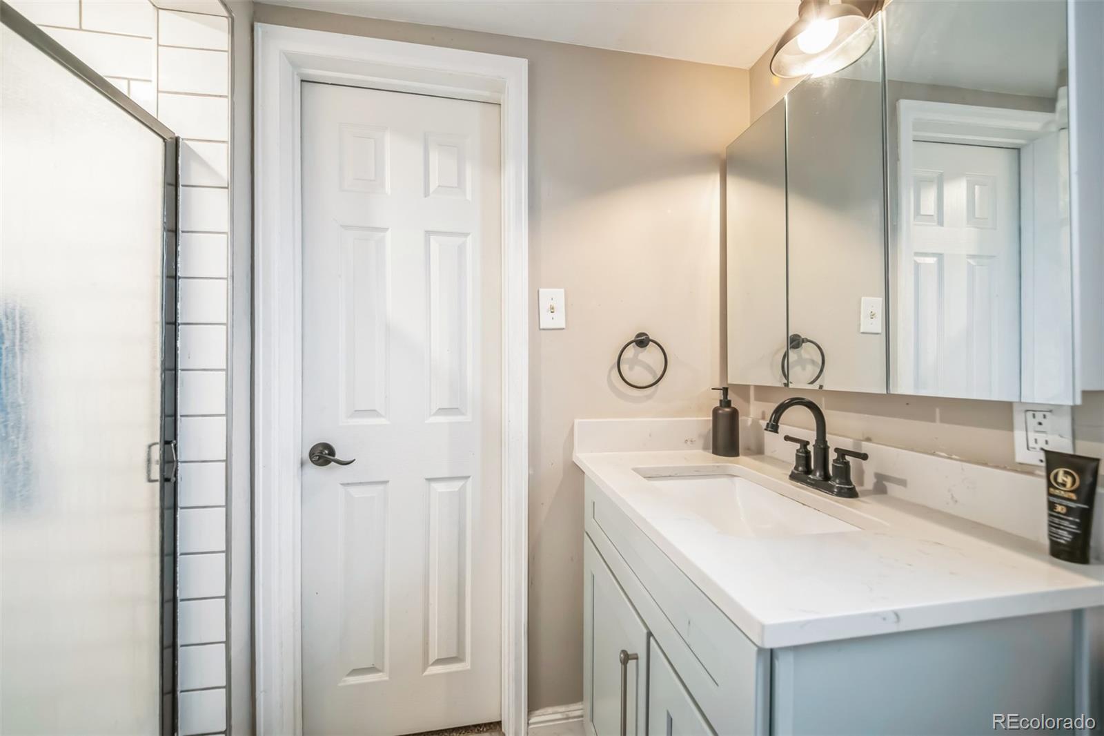 840 Tucson Street Aurora, CO 80011 - Photo 11 of 29 a bathroom with a sink and a mirror