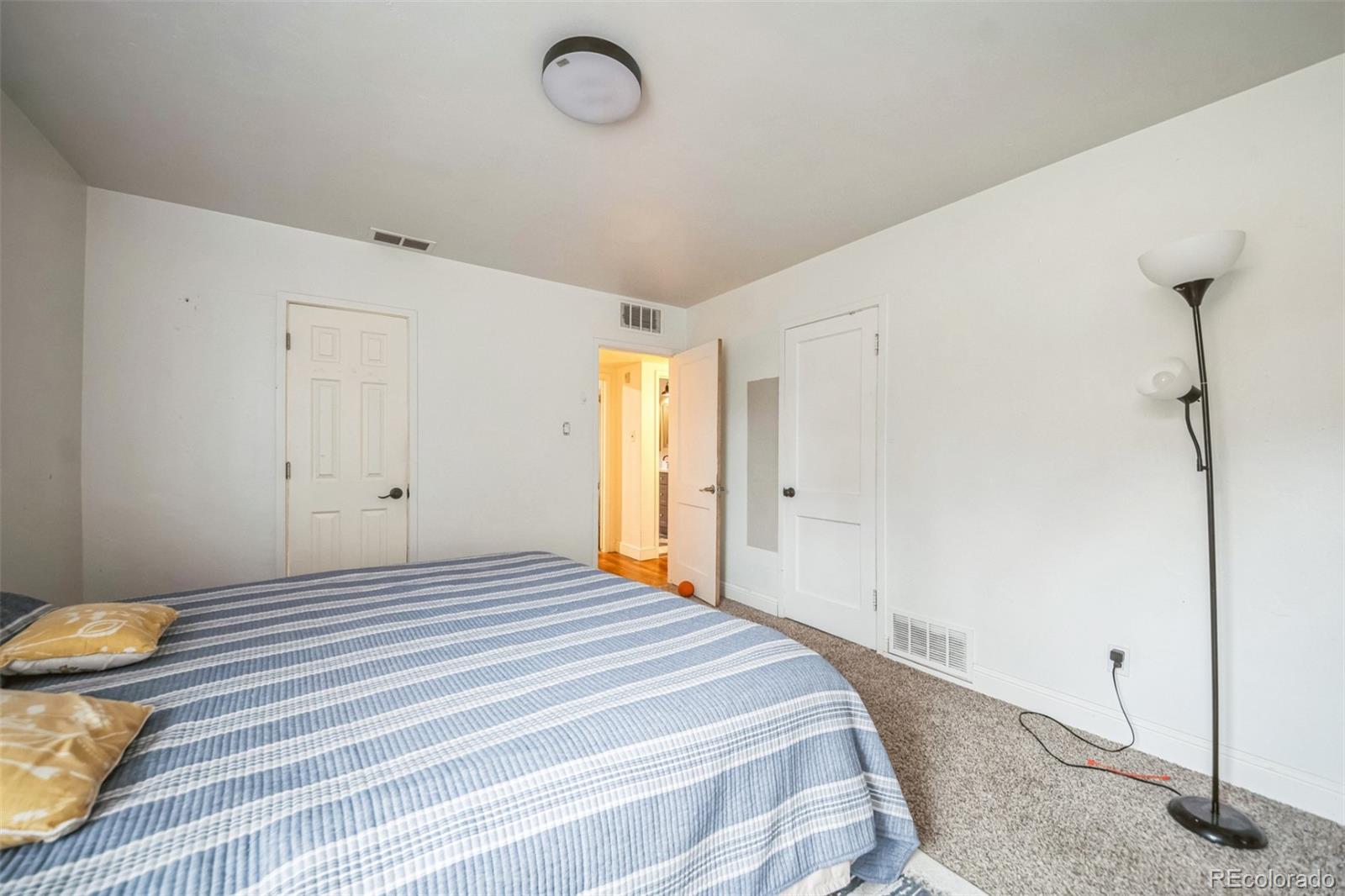 840 Tucson Street Aurora, CO 80011 - Photo 20 of 29 a bedroom with a bed and a table