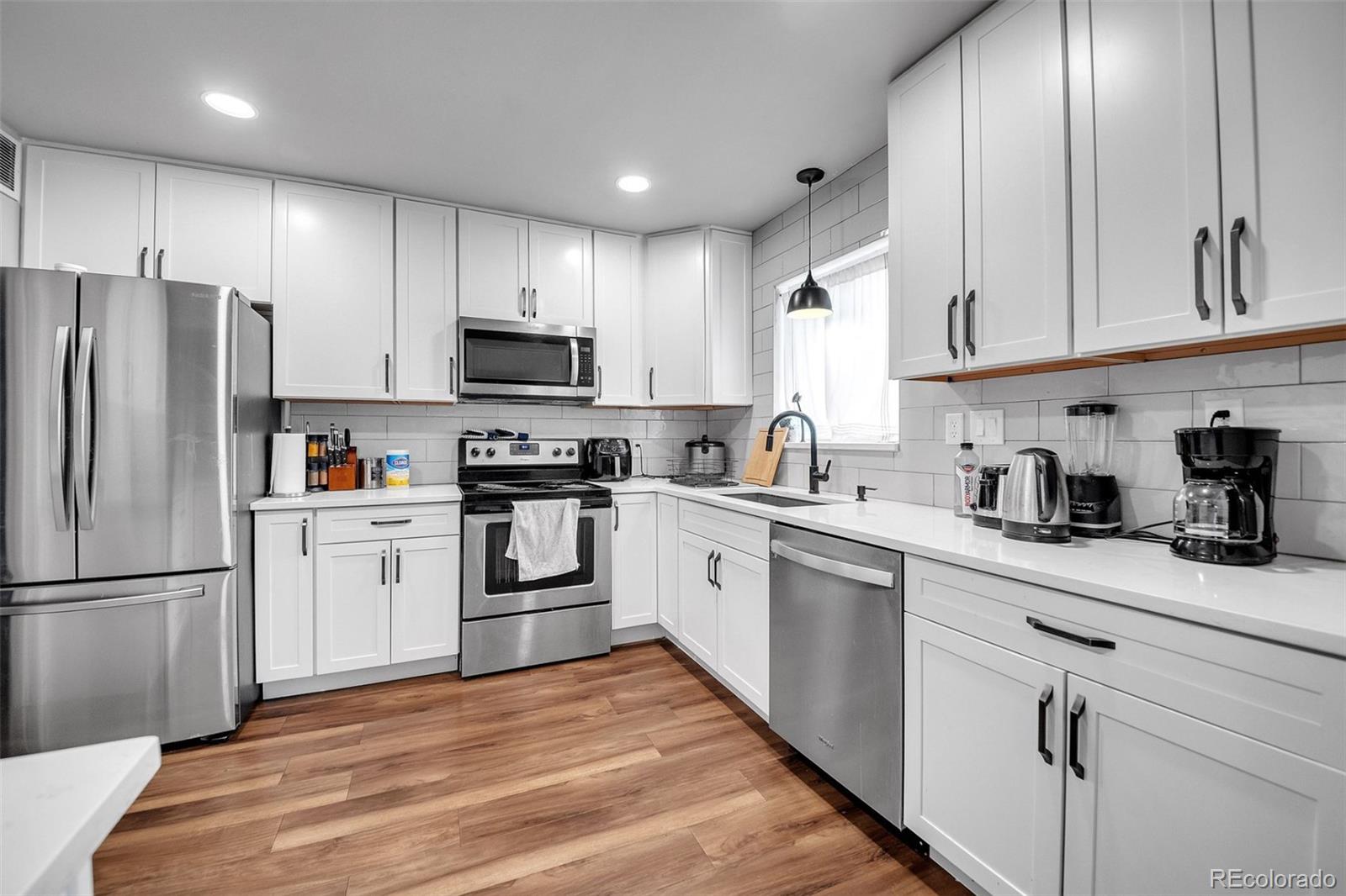 840 Tucson Street Aurora, CO 80011 - Photo 2 of 29 a kitchen with granite countertop a refrigerator stove top oven and sink