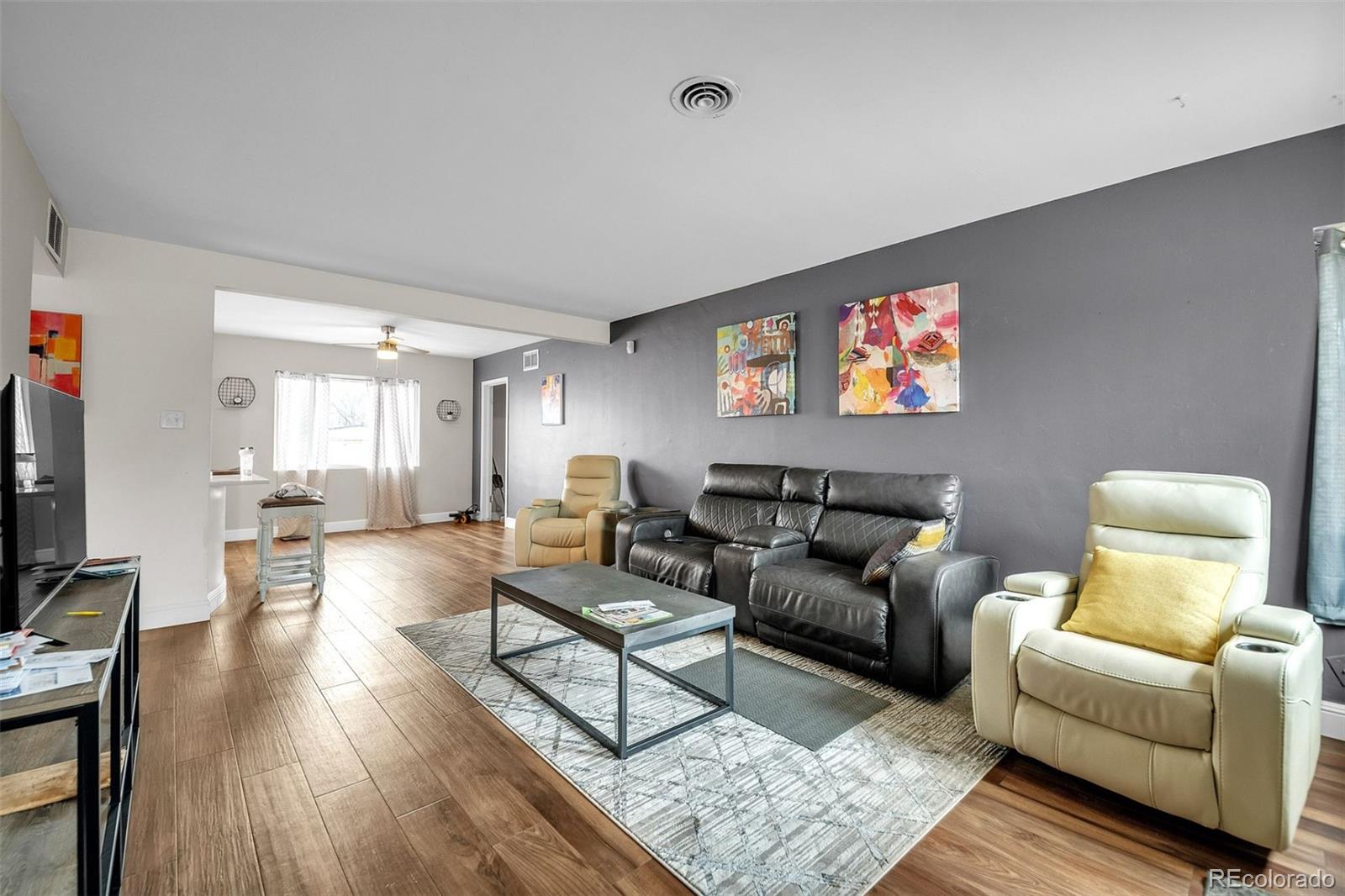 840 Tucson Street Aurora, CO 80011 - Photo 26 of 29 a living room with furniture and a flat screen tv