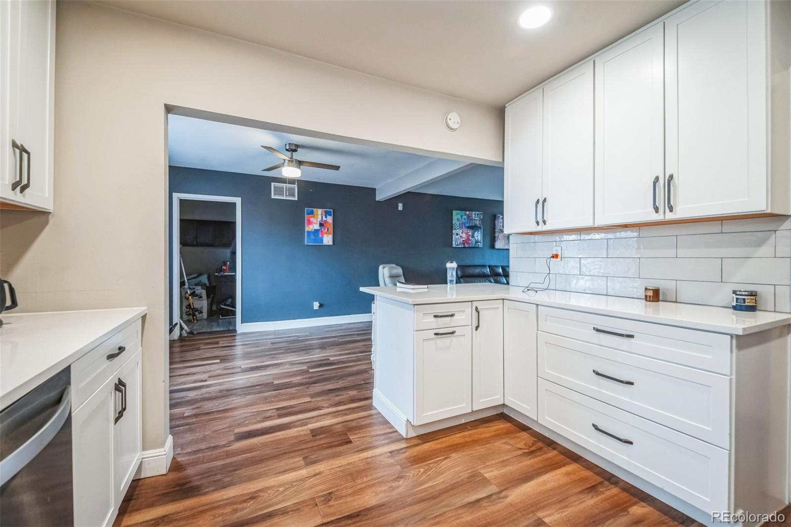 840 Tucson Street Aurora, CO 80011 - Photo 3 of 29 a kitchen with granite countertop white cabinets and white appliances