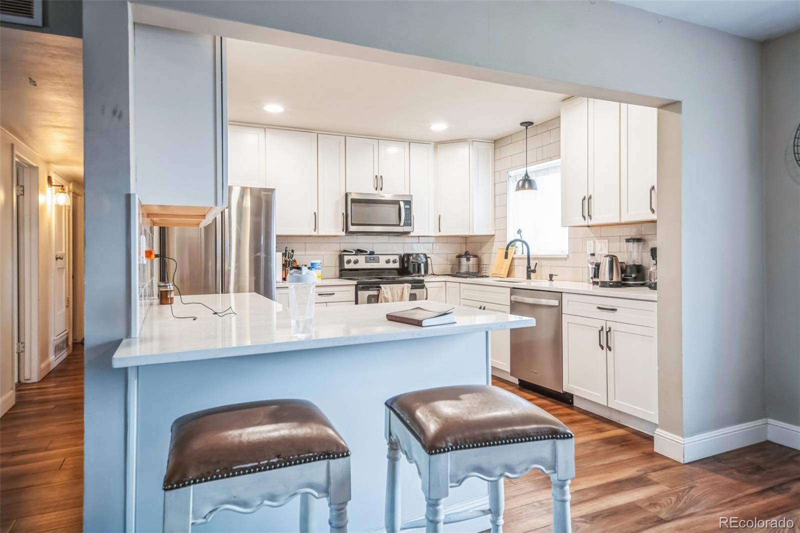 840 Tucson Street Aurora, CO 80011 - Photo 6 of 29 a kitchen with white cabinets and appliances