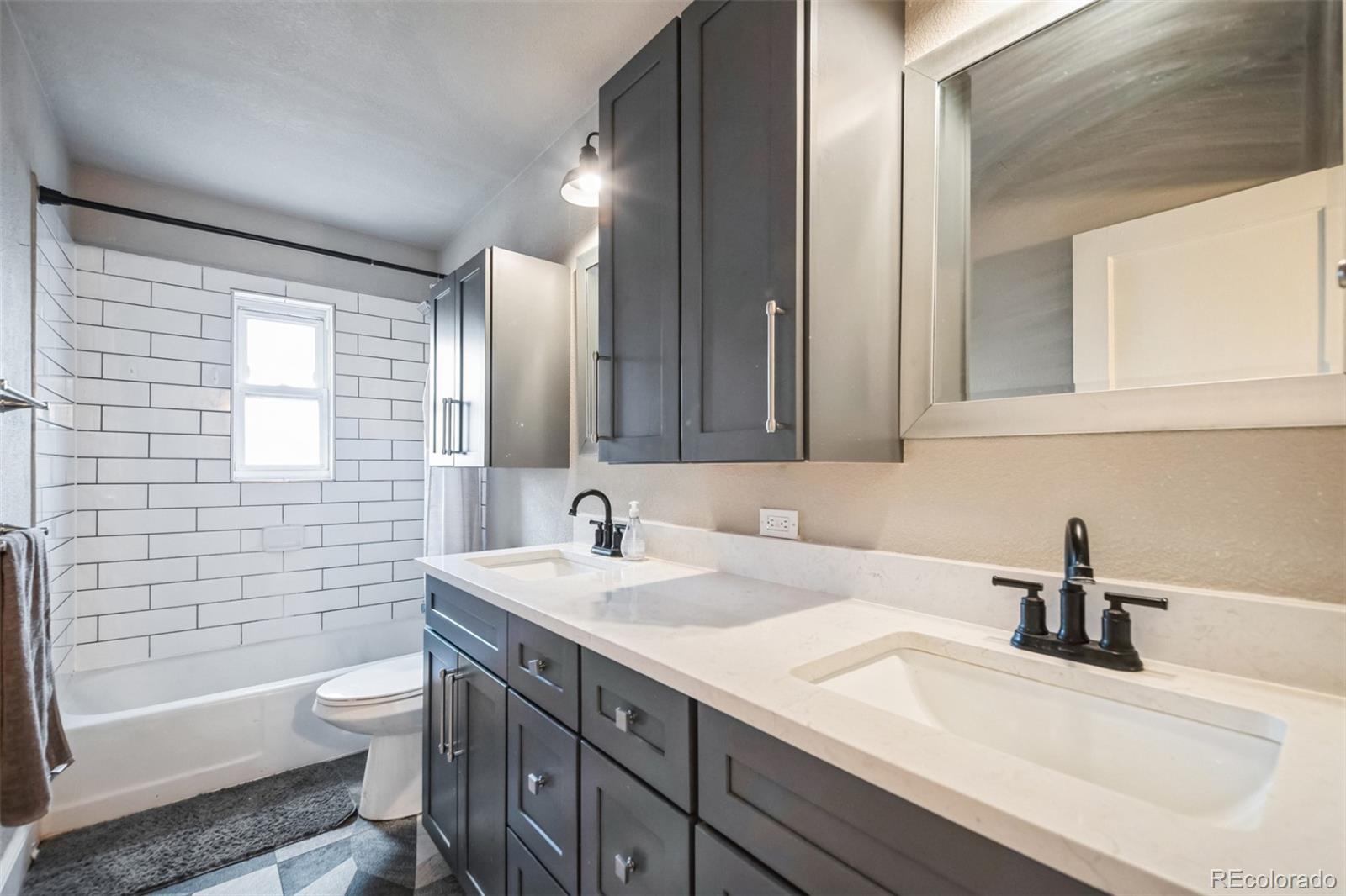 840 Tucson Street Aurora, CO 80011 - Photo 10 of 29 a bathroom with a sink a toilet and mirror