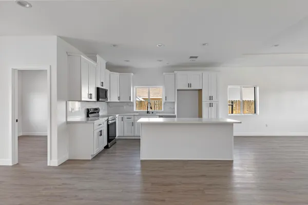 a large kitchen with cabinets wooden floor and stainless steel appliances