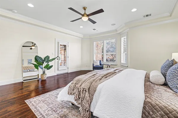 a spacious bedroom with a bed and a potted plant