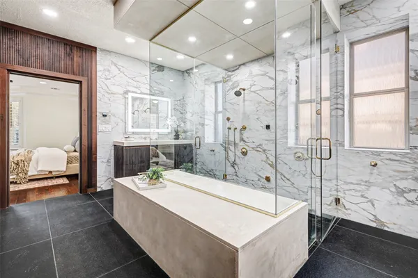 a spacious bathroom with a tub shower and sink