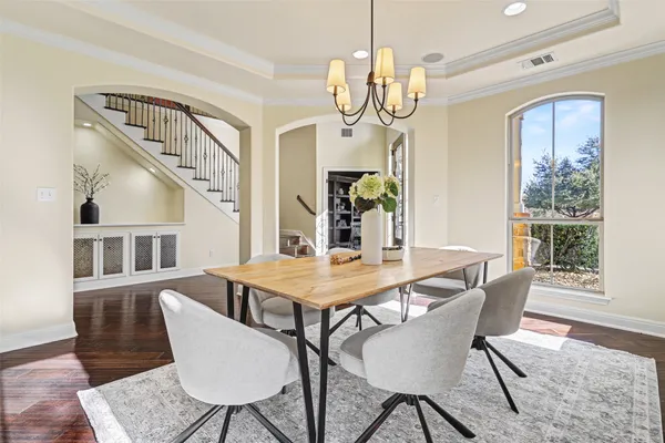a view of a dining room with furniture a chandelier and wooden floor