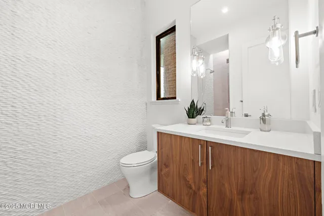 a bathroom with a granite countertop sink a toilet and a mirror