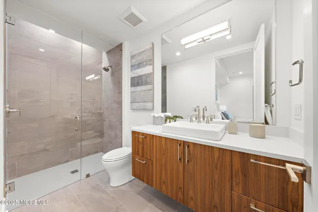 a bathroom with a double vanity sink toilet and shower