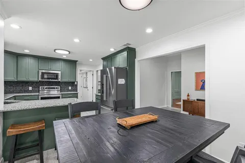 a living room with furniture flat screen tv and kitchen view