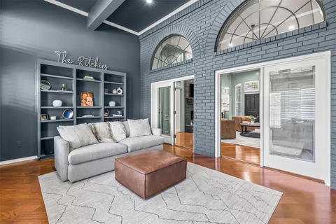 a living room with furniture a rug and a floor to ceiling window
