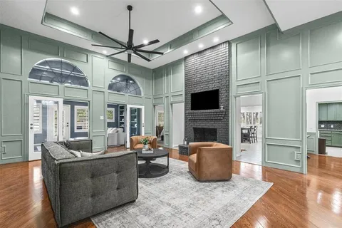 a living room with furniture a fireplace and a ceiling fan