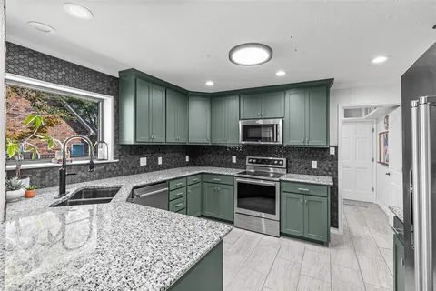 a kitchen with stainless steel appliances granite countertop a sink stove and refrigerator