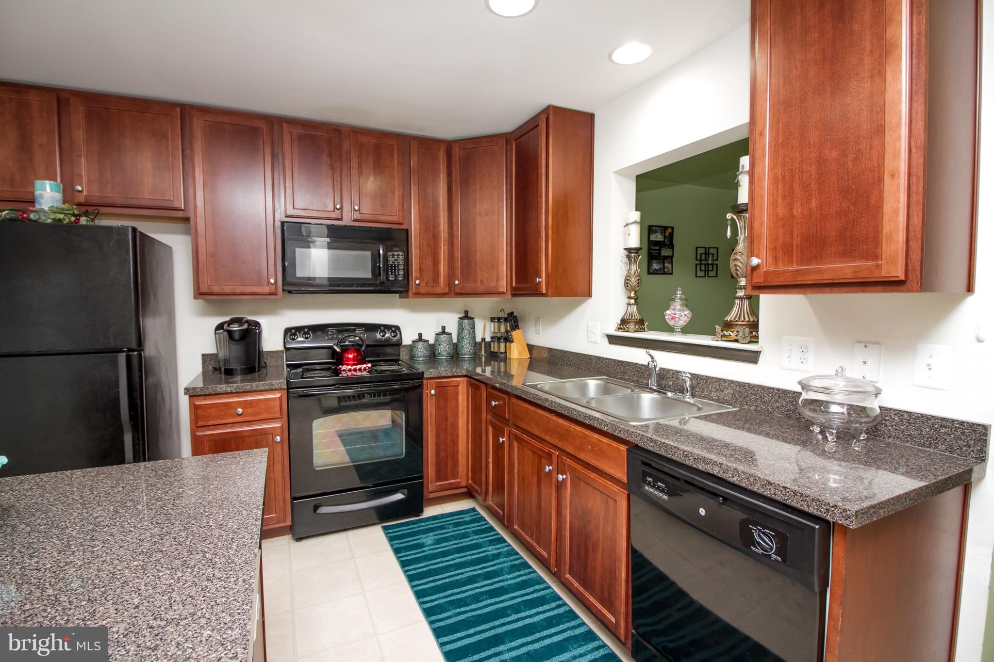 1217 Mare Street Ranson, WV 25438 - Photo 4 of 23 a kitchen with granite countertop stainless steel appliances and wooden cabinets