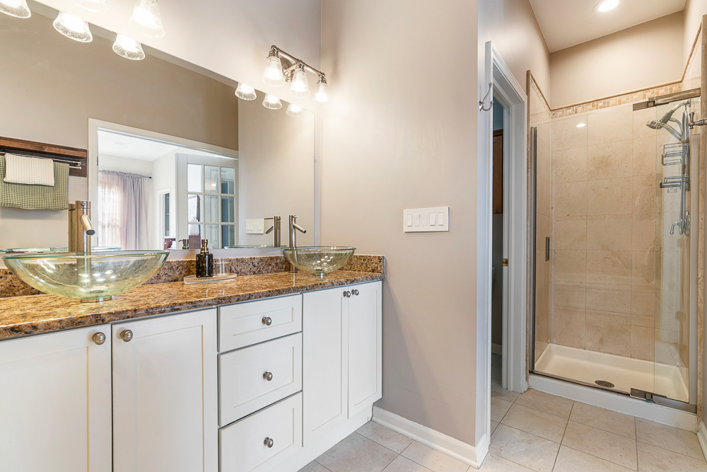 1002 West Altgeld Street, Unit 1002 Chicago, IL 60614 - Photo 16 of 39 a bathroom with a granite countertop sink mirror and shower