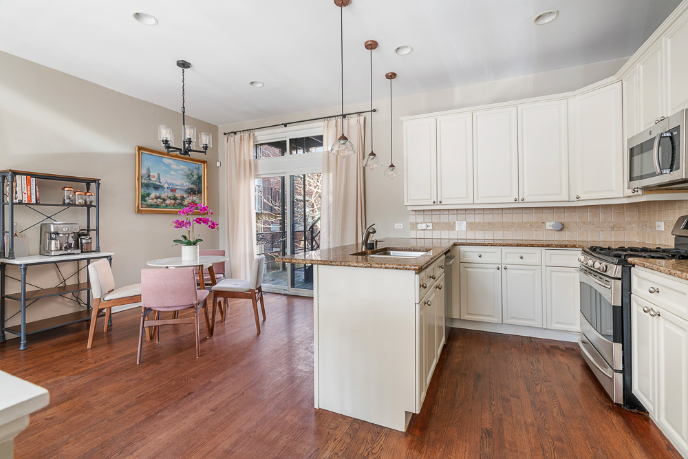 1002 West Altgeld Street, Unit 1002 Chicago, IL 60614 - Photo 6 of 39 a kitchen with a table chairs refrigerator and cabinets